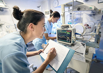 A nurse checking a computer for a patient