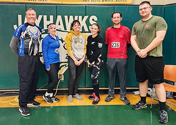 Six people stand together in the Physical Education Complex at SUNY JCC after completing a 5K.