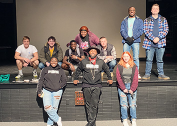 Storyteller Odd?Rod stands along the stage of the Scharmann Theatre with SUNY JCC students.