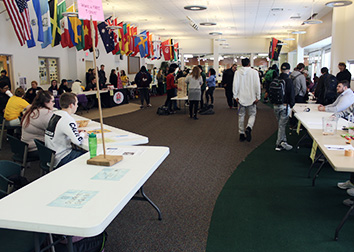 Students visit tables set up by college clubs an organizations at an involvement fair.