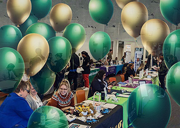A line of tables at a job fair with people around them and AI generated balloons floating in the areas around the tables.