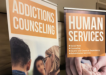 A banner with people talking and the words "Addictions Counseling" above their heads, and another banner to the right with younger hands gently holding an older one, with the words "Human Services Social Work, Counseling, Alcohol and Chemical Dependency, Rehabilitation Services."