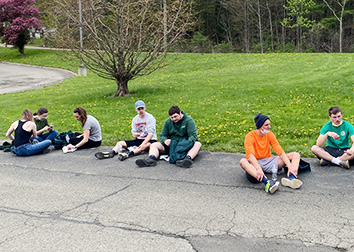 Students line a pathway on the SUNY JCC Jamestown Campus, eating hot dogs after the annual Hot Dog Run.