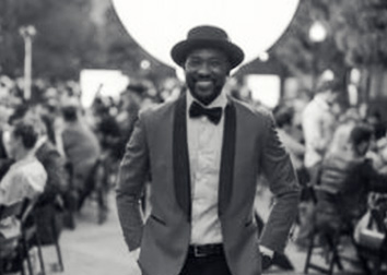 Rocky Peter standing in a road in a suit.