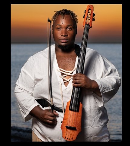 A person dressed in white holding a cello.