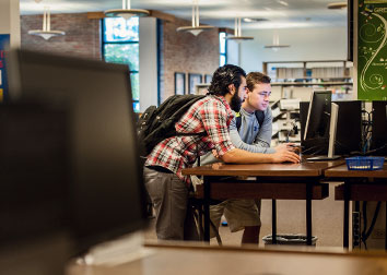 Two students look at a computer