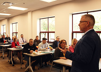 An instructor speaks to a room full of people