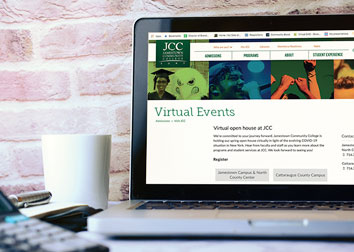 A a laptop computer screen showing a college virtual events webpage with a mug nearby and a brick wall behind.