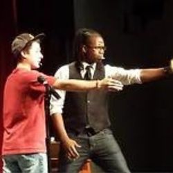 Randy Shine performing on stage with a guest to his right
