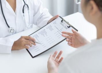 A medical professional goes over a health check document with a patient.