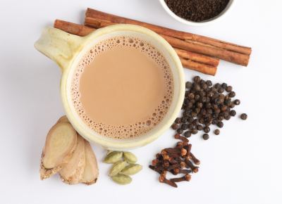An overhead view of a cup of tea surround by tea ingredients.