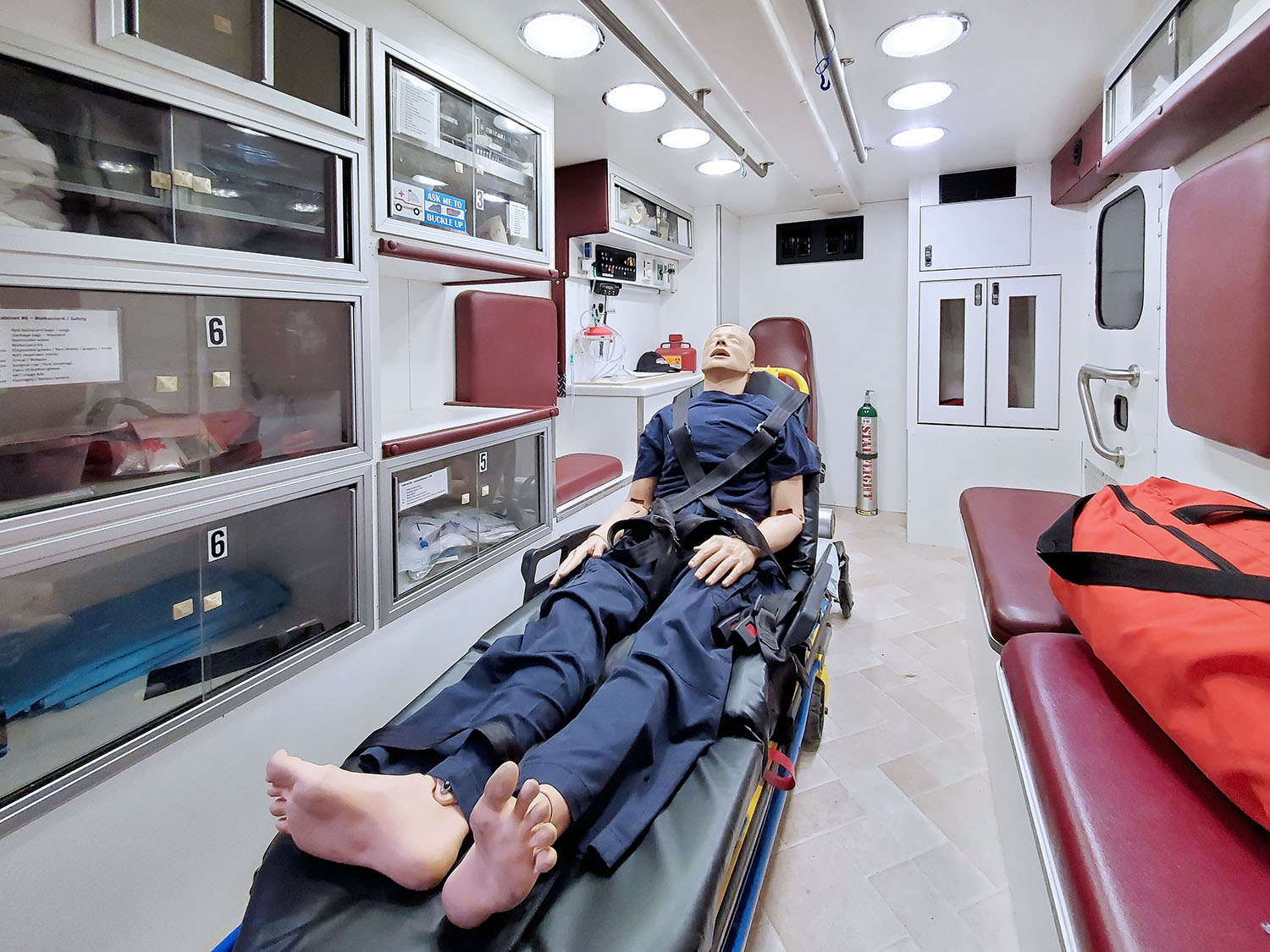 Mock ambulance in the ALSTAR EMS training center with all components of a real ambulance, including patient area, emergency resources, seating, and layout