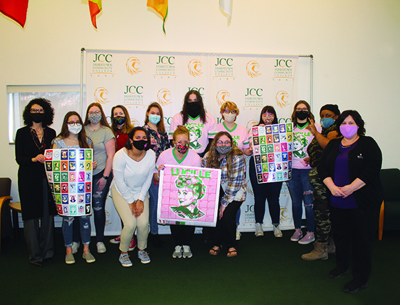 A picture of 14 students and faculty members holding a photo of a mosaic of Lucille Ball