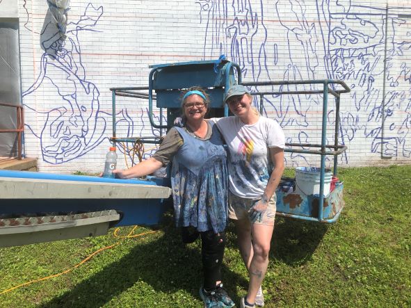 SUNY JCC student intern Jackie Hitchcock poses with muralist Meg Saligman at the Heart of Olean Mural site.