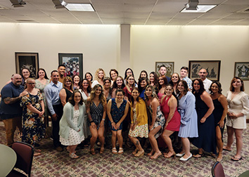 A group of people pose together before participating in a pinning ceremony at SUNY JCC.
