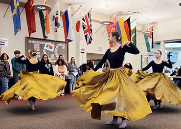 Dancers twirling under international flags at a "Go Global!" International Fair.
