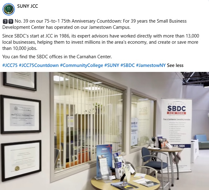 Office entrance of the SBDC at SUNY JCC, featuring framed certificates on the wall, brochures on a round table, and a banner with contact information.