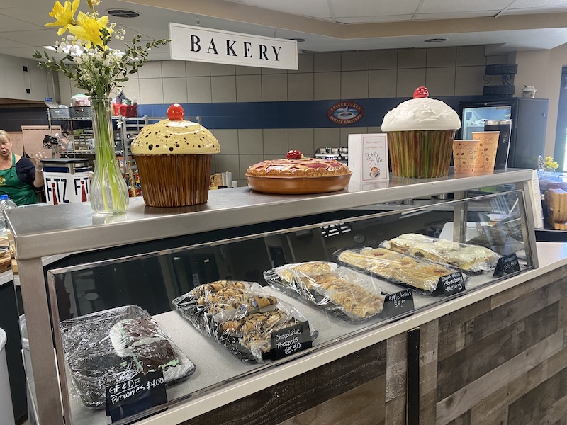 A glass case filled with tasty treats inside a bakery area.