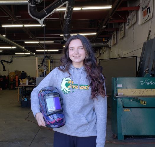 JCC student Ireland Hagglund holding welding helmet