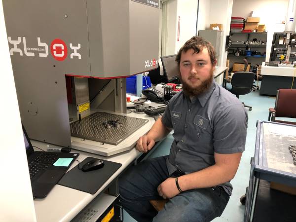 Jordan VanGorder sitting at manufacturing machine.