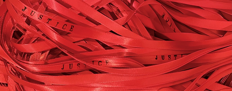 red ribbons with the word justice written on them