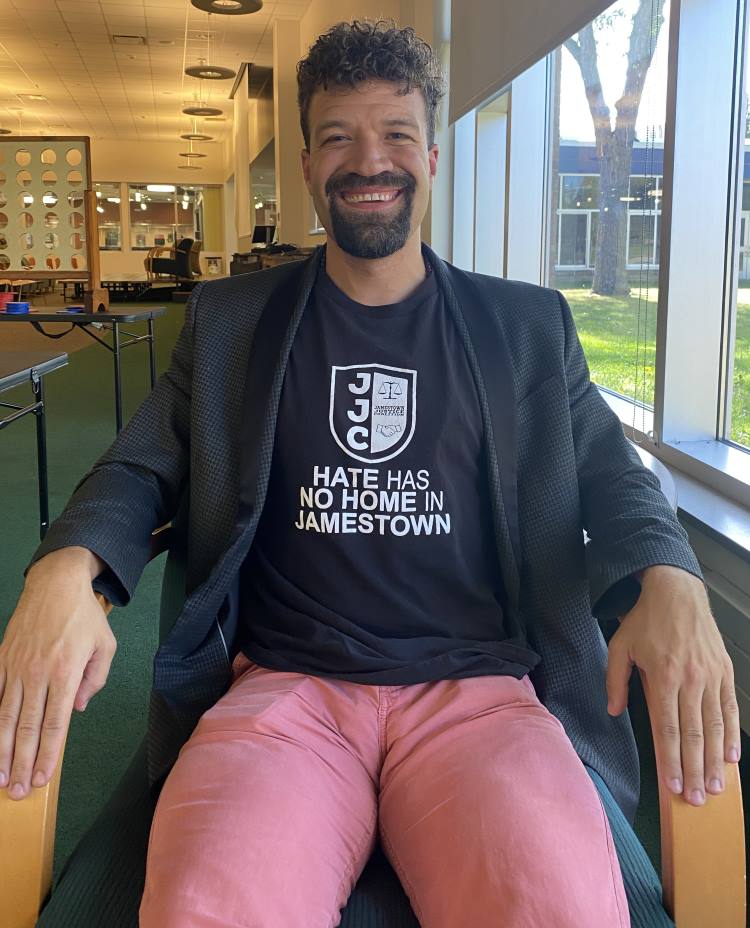 A person sitting in a chair smiling for a photo.