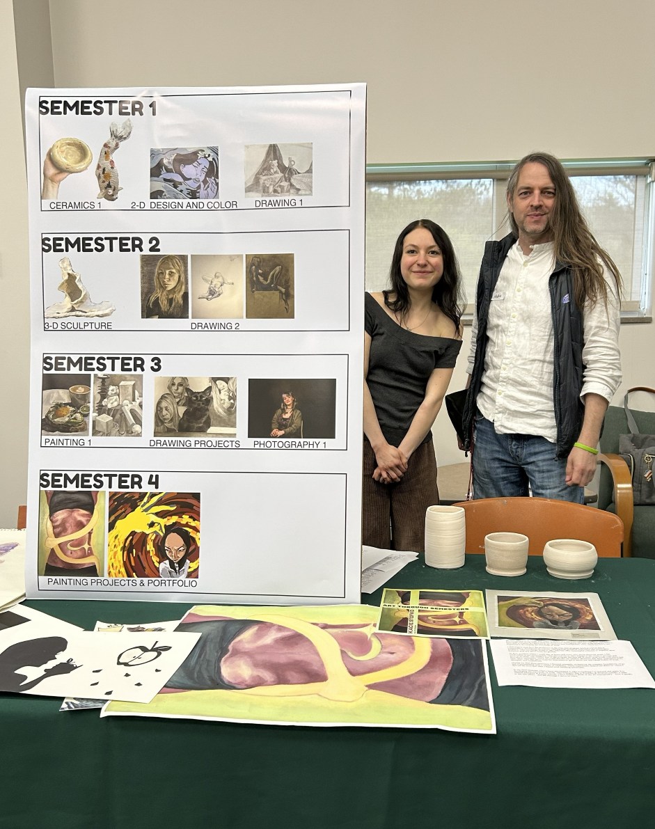 A poster board displays student artwork organized by semester, with "Semester 1" showing ceramics and drawing, "Semester 2" featuring sculpture and drawing, "Semester 3" with painting, drawing, and photography, and "Semester 4" showcasing painting projects and a portfolio. Two individuals stand to the right of the poster.