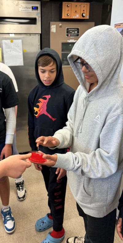 Two students look at a microbiology lab bacteria culture.