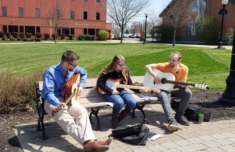 JCC students play guitar outside on campus