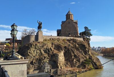 An image of a castle-like building overlooking a waterway.