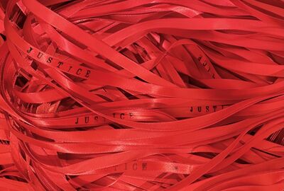 A loose coil of ribbons with the word "Justice" printed on them. 