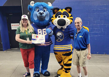Carissa Bentley stands with Billy the Buffalo, Sabretooth, and alumnus and former JCC Staff member, Felix Muzza.
