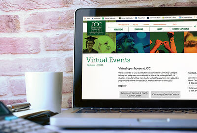 A a laptop computer screen showing a college virtual events webpage with a mug nearby and a brick wall behind.