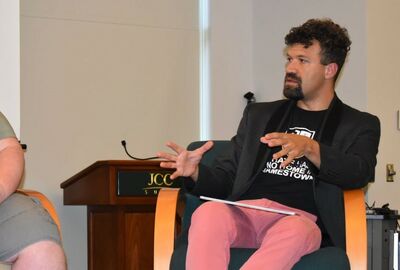 A person moves their hands while talking to others.