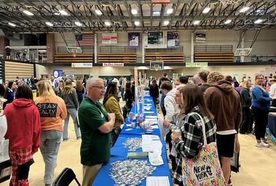 A JCC employee talking with high school students about healthcare programs.