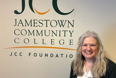 A smiling woman poses with a Jamestown Community College JCC Foundation logo in the background.