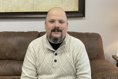 Daniel Gonzalez sitting on a brown couch.