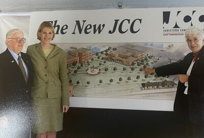 Three people pose beside an architectural rendering labeled “The New JCC,” promoting a community center project in a formal, hopeful setting.
