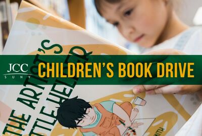 A young child studies an illustrated book among other books beneath a green “Children’s Book Drive” banner, conveying a warm, hopeful literacy campaign.